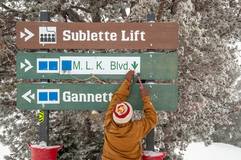 Marvin Howard adjusts signage on April Fools Day, Jackson Hole, WY.